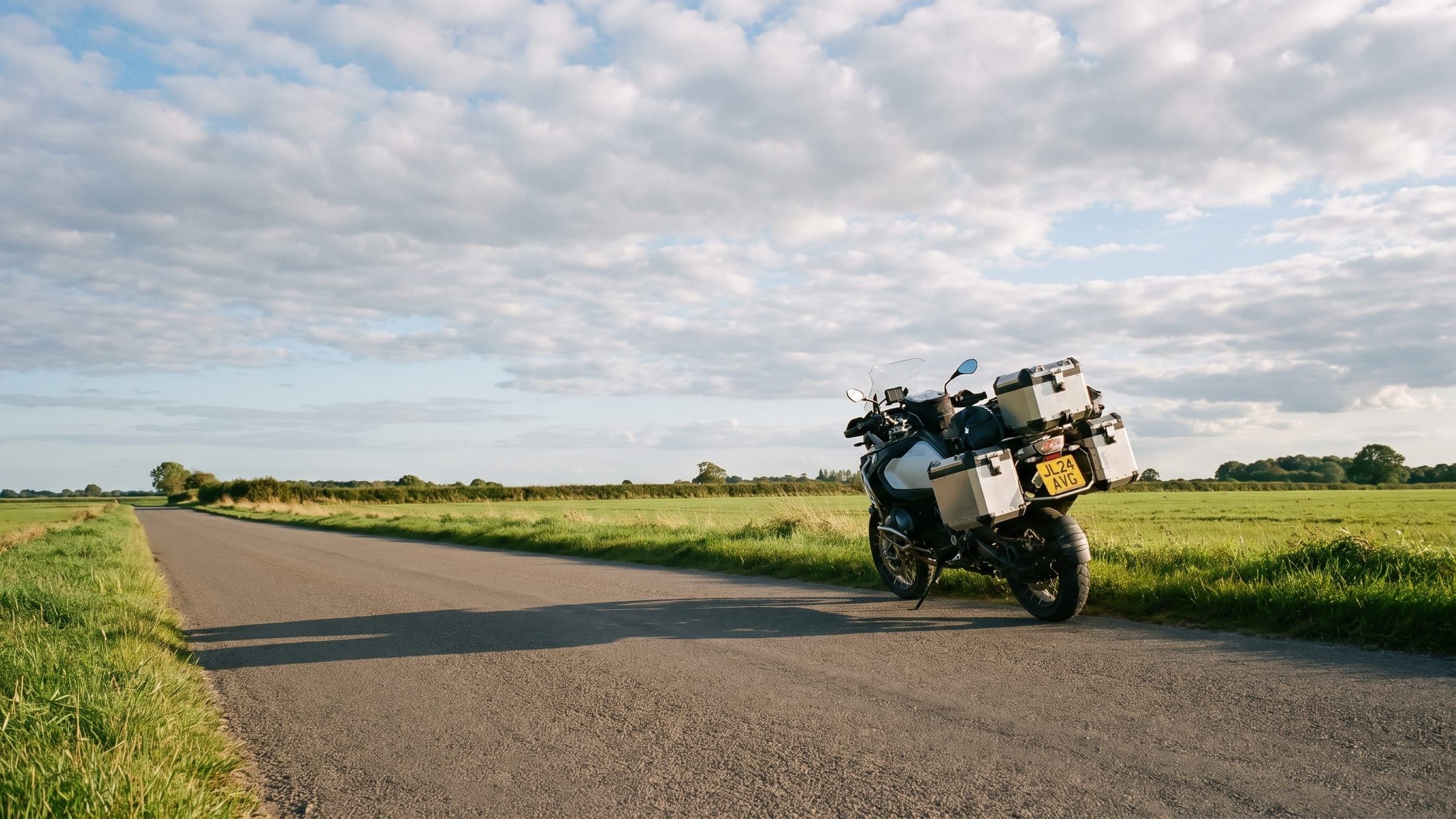 A motorcycle parked on a country road verge under a wide Norfolk sky